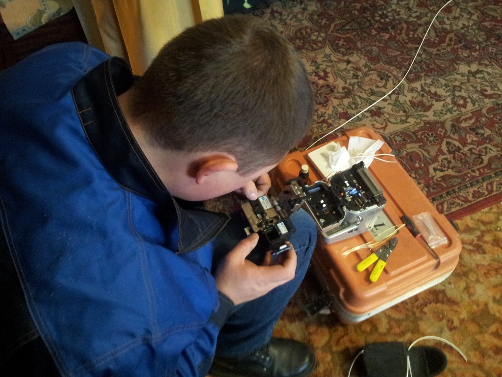 Александр спаивает два оптоволоконных кабеля в специальном сварочном аппарате, Фото с места события собственное