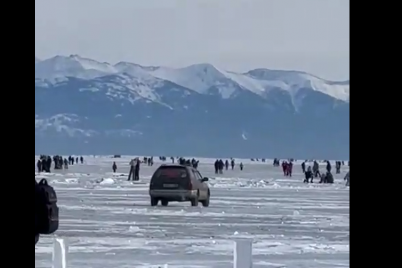 Автомобиль ехал сквозь толпу туристов на льду Байкала в Листвянке